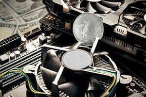 Bitcoin. New virtual money. Bitcoins lie on the video card, concept of mining. photo