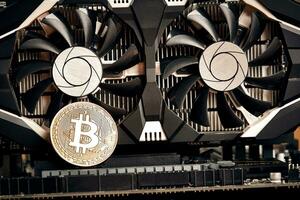 Bitcoin. New virtual money. Bitcoins lie on the video card, concept of mining. photo