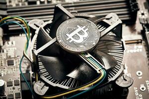 Bitcoin. New virtual money. Bitcoins lie on the video card, concept of mining. photo