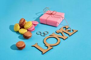 Macaroons and gift box on a blue background with the words I lov photo