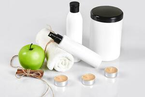 Natural spa beauty treatment cleansing products with apple on white background. photo