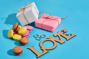 Macaroons and gift boxes on a blue background with the words I l photo