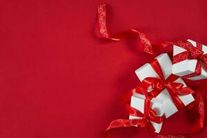 White gift boxes with red ribbon on red background. Valentines d photo