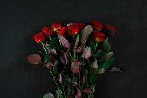 Bouquet of red roses on a black background. Top view photo