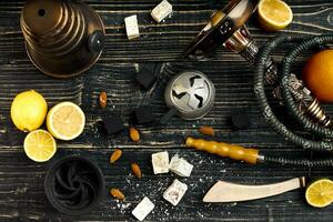 Arabic hookah with a tobacco flavor of a mixture of lemon. Top view of a dark wooden background photo