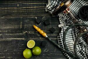 Arabic hookah with a tobacco flavor of a mixture of lime. Top view of a dark wooden background photo