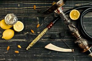 Dismantled parts of hookah on a wooden background with lemon fru photo