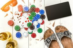 Gambling. Poker chips, cards and the dice nearby tablet on wooden table. Top view. Copyspace. Poker photo