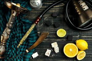 Top view of Hookah with orange fruit on a wooden background photo