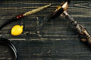 Dismantled parts of hookah on a wooden background with lemon fru photo