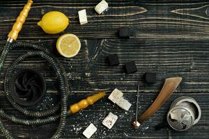 Arabic hookah with a tobacco flavor of a mixture of lemon. Top view of a dark wooden background photo