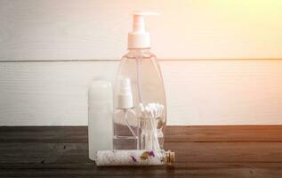 Spa beauty cosmetic products on white and black wooden background. Copyspace. Sun flare photo