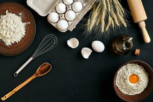 Pasta cooking ingredients on black kitchen table. Top view with space for your text photo