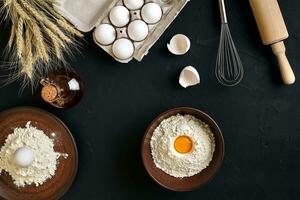 Pasta cooking ingredients on black kitchen table. Top view with space for your text photo