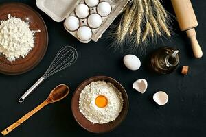 Pasta cooking ingredients on black kitchen table. Top view with space for your text photo