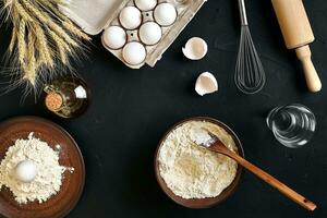 Pasta cooking ingredients on black kitchen table. Top view with space for your text photo