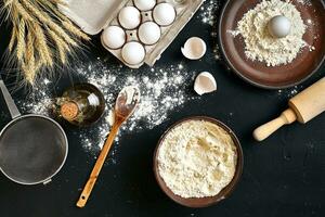 Pasta cooking ingredients on black kitchen table. Top view with space for your text photo