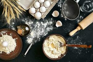 Pasta cooking ingredients on black kitchen table. Top view with space for your text photo