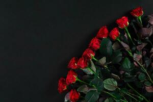 Bouquet of red roses on a black background. Top view photo