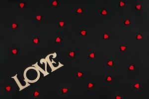 Valentines day background. Red hearts on the black desk photo