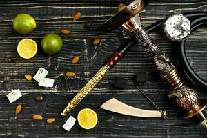 Dismantled parts of hookah on a wooden background with lime frui photo