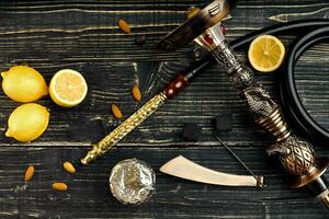 Dismantled parts of hookah on a wooden background with lemon fru photo