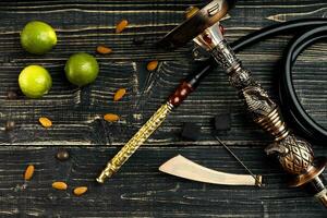 Dismantled parts of hookah on a wooden background with lime frui photo