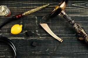 Dismantled parts of hookah on a wooden background with lemon fru photo