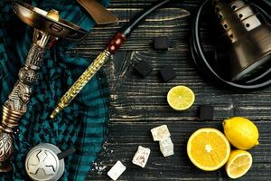 Top view of Hookah with orange fruit on a wooden background photo
