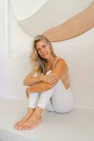 Healthy woman sitting  on  floor and relaxing after  yoga or fitness . Female  taking a break from workout. photo