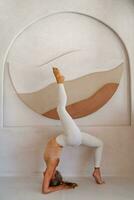 Yoga and healthy life concept. Blond slim woman doing yoga asanas over decoration wall in studio. photo