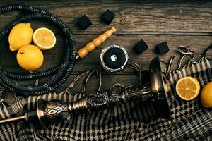 Dismantled parts of hookah on a wooden background with lemon fru photo