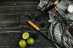 Arabic hookah with a tobacco flavor of a mixture of lime. Top view of a dark wooden background photo