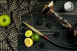 Dismantled parts of hookah on a wooden background with lime and photo