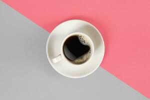 A cup of black coffee on gray and pink background. View from above. photo