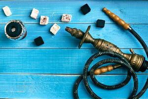 Parts of the hookah on blue wooden background. Hookah accessorie photo