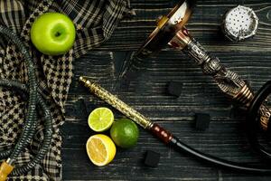 Dismantled parts of hookah on a wooden background with lime and photo