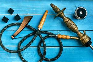 Parts of the hookah on blue wooden background. Hookah accessorie photo