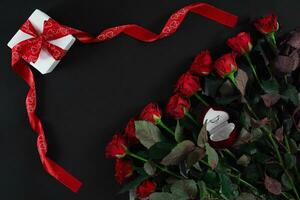 rojo rosas, anillo y regalo caja en negro antecedentes foto