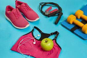 Flat lay of dumbbell, bottle of water, jump rope and sneaker, sport equipments, fitness items, top view photo