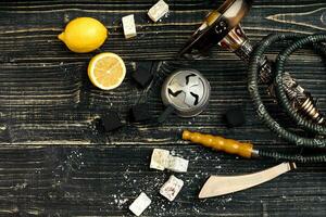 Dismantled parts of hookah on a wooden background with lemon fru photo