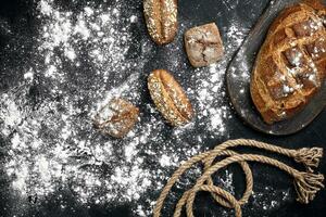 Mixed breads on black table. Top view with copy space. photo