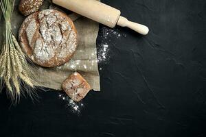 Freshly baked bread on dark kitchen table, top view photo