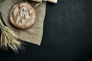 Freshly baked bread on dark kitchen table, top view photo