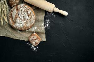 Freshly baked bread on dark kitchen table, top view photo