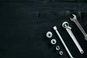 Tools for car repair in Workshop. Car repair equipment on black wooden background in car repair shop photo