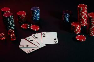 Casino chips and cards on black table surface. Gambling, fortune, game and entertainment concept - close up photo