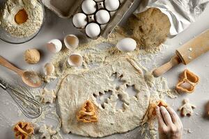 Baking preparation. Raw dough and cutters for the holiday cookies on a white table. Top view. photo