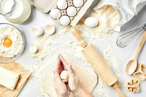 Baking preparation. Raw dough and cutters for the holiday cookies on a white table. Top view. photo