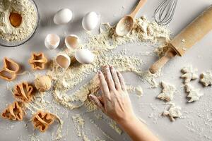 Baking preparation. Raw dough and cutters for the holiday cookies on a white table. Top view. photo